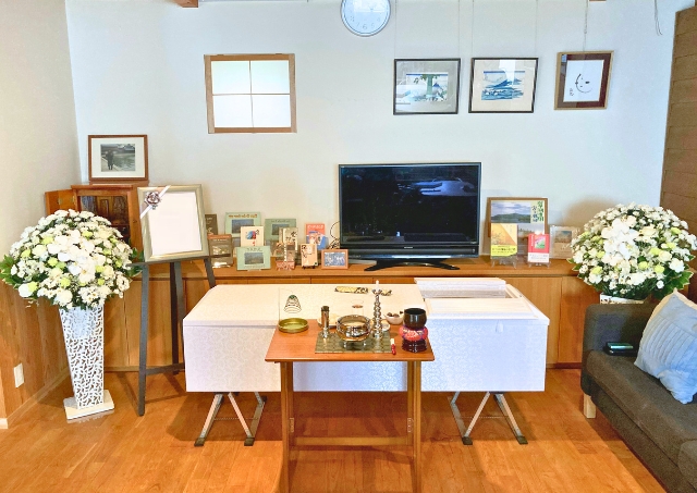 板橋区で株式会社ライフセレモニートラストが自宅葬用の白木棺と供花を並べた居間の祭壇